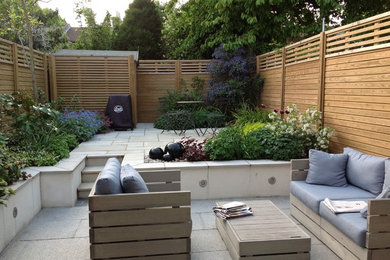 This is an example of a contemporary patio in London with fencing.