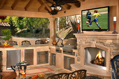 Photo of a large classic back patio in Orange County with an outdoor kitchen and a gazebo.