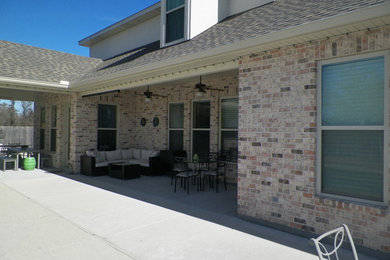 Photo of a medium sized classic back patio in New Orleans with a roof extension.