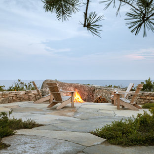 Idee per un ampio patio o portico minimal dietro casa con un focolare, pavimentazioni in pietra naturale e nessuna copertura