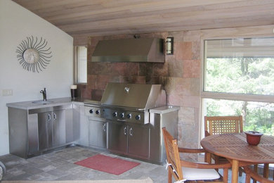 Aménagement d'une terrasse arrière contemporaine avec une cuisine d'été, du carrelage et une extension de toiture.