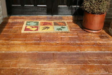 This is an example of a medium sized back patio in Austin with stamped concrete and an awning.