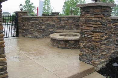 Foto de patio de tamaño medio sin cubierta en patio trasero con brasero y adoquines de piedra natural