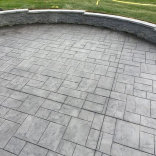 Esempio di un patio o portico chic di medie dimensioni e dietro casa con cemento stampato e nessuna copertura