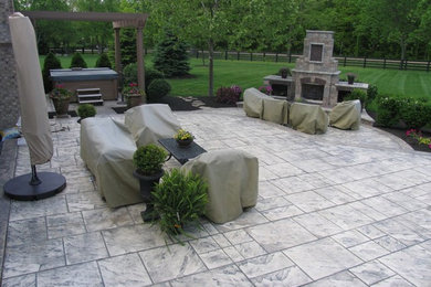 This is an example of a large classic back patio in Columbus with concrete paving.