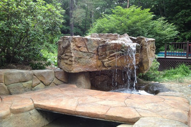 Inspiration for a mid-sized rustic backyard stamped concrete patio fountain remodel in Burlington