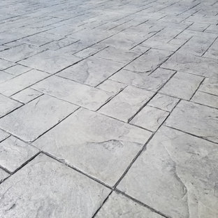 Foto di un grande patio o portico classico dietro casa con un focolare e cemento stampato