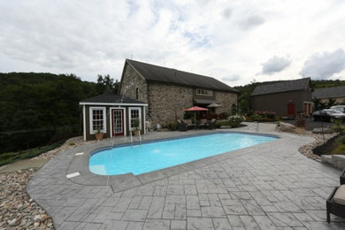 Foto de patio de estilo de casa de campo de tamaño medio sin cubierta en patio trasero con fuente y suelo de hormigón estampado