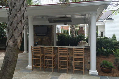 Example of a large classic side yard stone patio kitchen design in Charleston with a gazebo