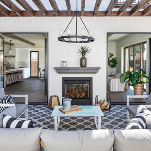 Immagine di un patio o portico mediterraneo con un caminetto, piastrelle e una pergola