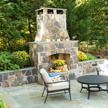 Stone backyard chimney, patio, retaining walls, outdoor kitchen, and stairs