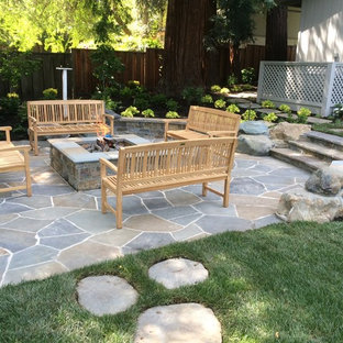Esempio di un grande patio o portico classico dietro casa con un focolare, nessuna copertura e pavimentazioni in pietra naturale