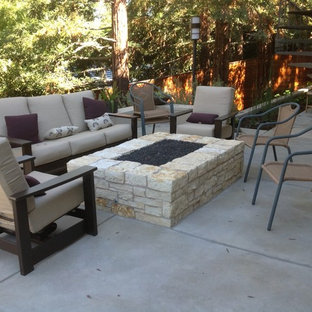 Idee per un patio o portico rustico di medie dimensioni e dietro casa con un focolare, pavimentazioni in cemento e un tetto a sbalzo