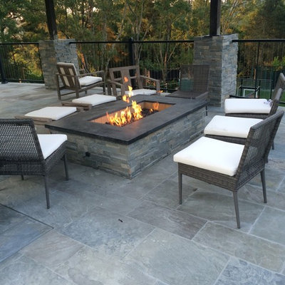 Large trendy backyard stamped concrete patio photo in Other with a fire pit and a roof extension