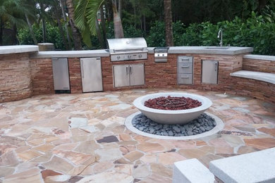 Diseño de patio actual grande sin cubierta en patio trasero con adoquines de piedra natural y cocina exterior