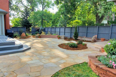Diseño de patio grande en patio trasero con adoquines de piedra natural