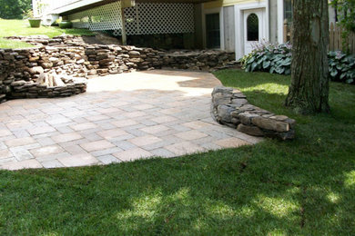 Foto de patio tradicional grande sin cubierta en patio trasero con adoquines de piedra natural y brasero
