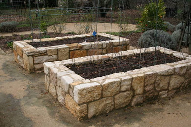 Ejemplo de patio campestre de tamaño medio en patio trasero con jardín de macetas y adoquines de piedra natural
