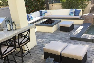 Small trendy backyard concrete paver patio photo in Orange County with a roof extension