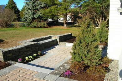 Example of a small backyard brick patio design in Portland Maine with no cover