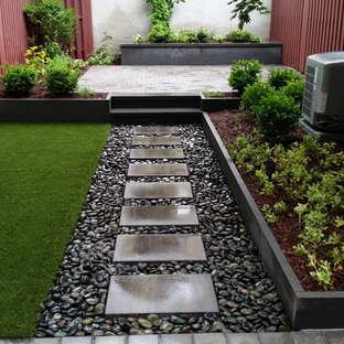 Modelo de patio actual, pequeño, sin cubierta, en patio trasero, con jardín de macetas y adoquines de piedra natural
