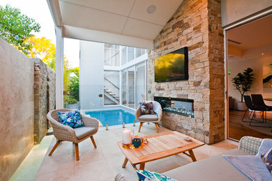 Example of a small beach style backyard tile patio design in Perth with a roof extension