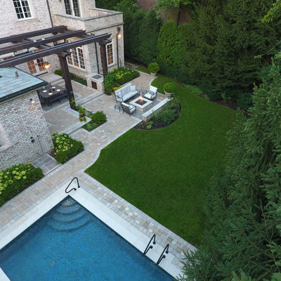 Patio kitchen - large traditional backyard stone patio kitchen idea in Chicago with a pergola