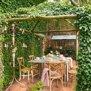 Foto di un patio o portico country di medie dimensioni e dietro casa con una pergola e piastrelle