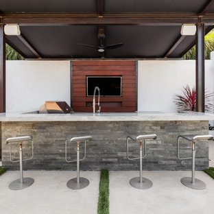 Large minimalist backyard concrete paver patio kitchen photo in Los Angeles with an awning