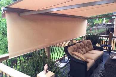 Medium sized back patio in Other with an awning.