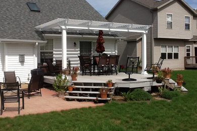 Example of a large backyard patio design in Chicago with an awning