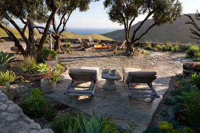 Diseño de patio rústico de tamaño medio en patio trasero con adoquines de piedra natural