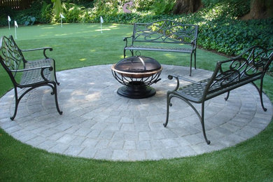 Example of a mid-sized transitional backyard concrete paver patio design in Portland with a fire pit and no cover