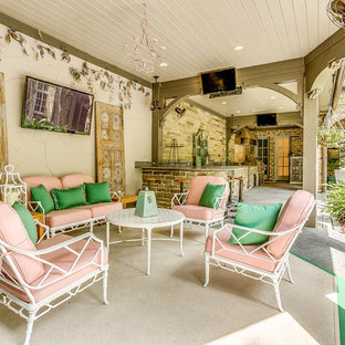 Immagine di un ampio patio o portico shabby-chic style dietro casa con pavimentazioni in pietra naturale e un tetto a sbalzo