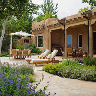Foto di un patio o portico stile americano di medie dimensioni e dietro casa con pavimentazioni in pietra naturale e un tetto a sbalzo