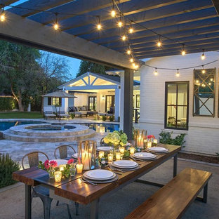 Inspiration for a large transitional backyard stone patio remodel in Phoenix with a pergola
