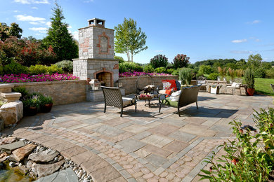 Inspiration for a large timeless backyard stone patio remodel in Philadelphia with a fire pit and no cover