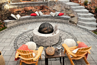 Foto de patio tradicional de tamaño medio sin cubierta en patio trasero con brasero y adoquines de piedra natural