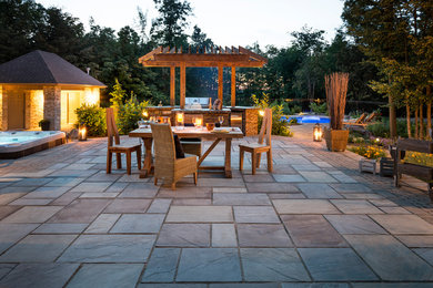 Inspiration pour une grande terrasse arrière traditionnelle avec une cuisine d'été, des pavés en pierre naturelle et aucune couverture.