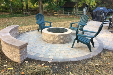Inspiration for a mid-sized timeless backyard concrete paver patio remodel in New York with a fire pit