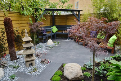 Inspiration for a small world-inspired courtyard patio in London with natural stone paving.