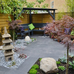 Immagine di un piccolo patio o portico etnico in cortile con pavimentazioni in pietra naturale