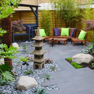 Immagine di un piccolo patio o portico etnico dietro casa con pavimentazioni in pietra naturale