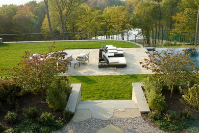 Diseño de patio clásico de tamaño medio sin cubierta en patio trasero con adoquines de piedra natural y brasero