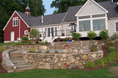 Modelo de patio rústico grande sin cubierta en patio trasero con brasero y adoquines de piedra natural