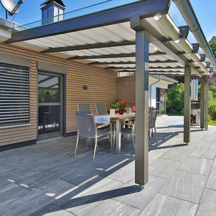 Immagine di un patio o portico minimal di medie dimensioni e nel cortile laterale con graniglia di granito e un parasole