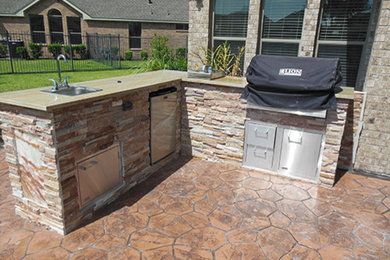 Backyard concrete patio kitchen photo in Houston with no cover