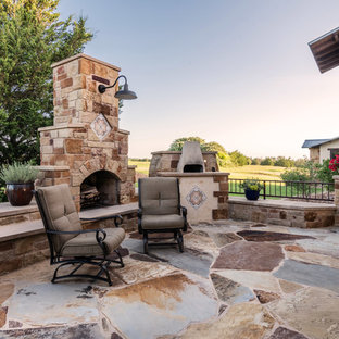 Expansive mediterranean courtyard patio in Austin with an outdoor kitchen, a pergola and natural stone pavers.