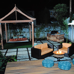 Esempio di un patio o portico etnico di medie dimensioni e dietro casa con un focolare, pavimentazioni in cemento e una pergola