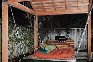 Inspiration for a mid-sized asian backyard concrete paver patio remodel in Sacramento with a fire pit and a pergola